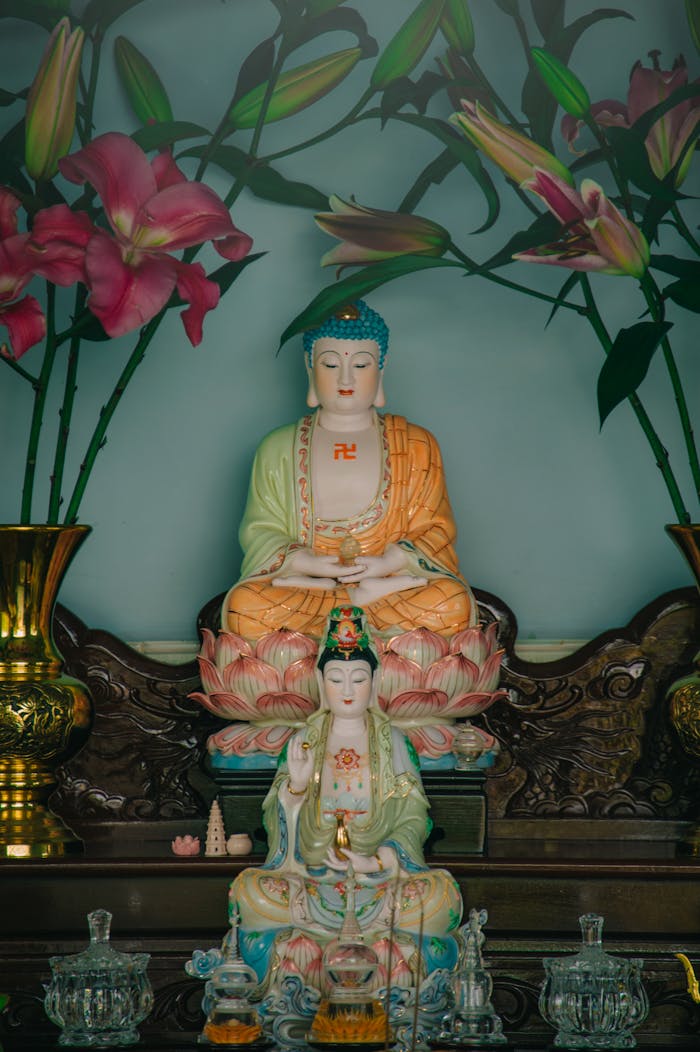 Home Intricate Buddhist altar with colorful statues and pink lilies for worship